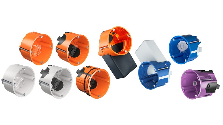 Ein Gruppenbild der KAISER Hohlwanddosen O-range®. Die Standardvariante ist orange, Schallschutzdosen blau, luftdichte Dosen lila und Halogenfreie sind über die drei Arten übergreifend weiß.
